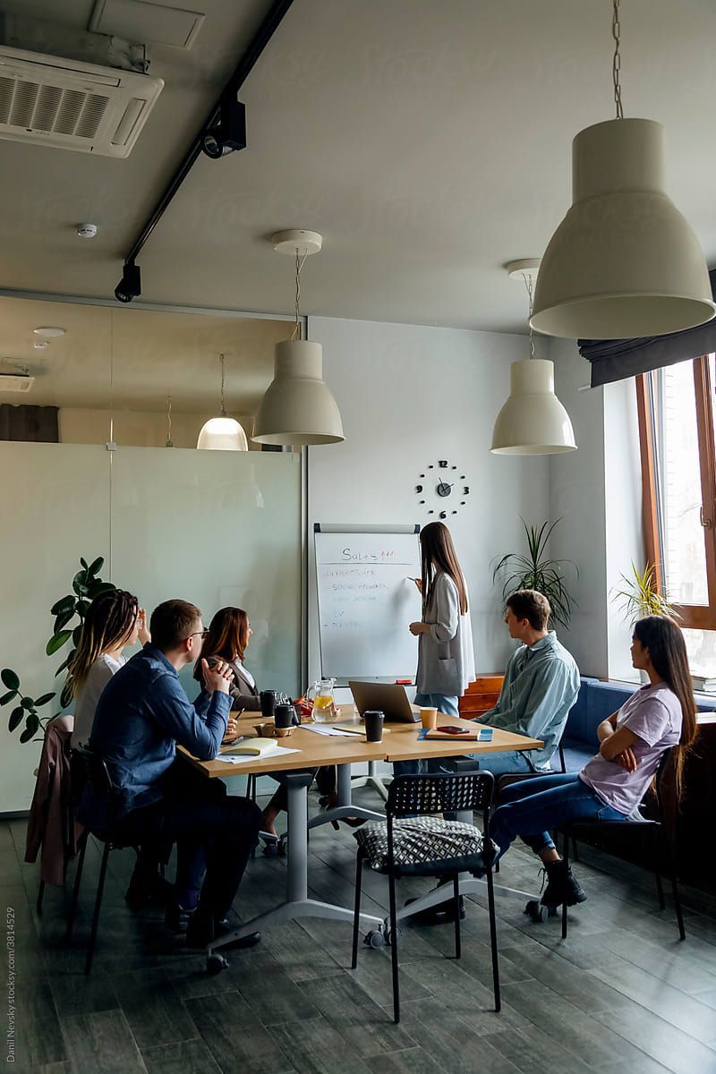 A small office team taking a standing movement break beside their desks